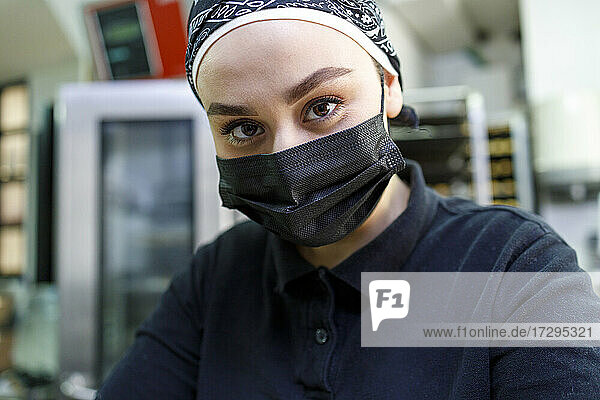 Besitzerin mit Gesichtsschutzmaske in einer Bäckerei