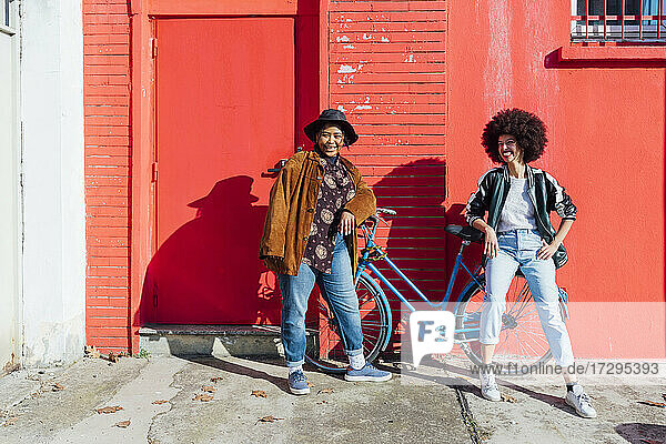 Junge Freunde  die sich lächelnd an ein Fahrrad lehnen