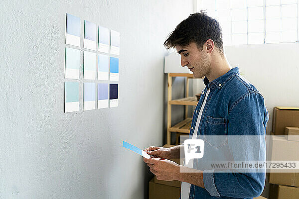 Geschäftsmann mit Blick auf blaue Karte vor der Wand eines Lagerhauses