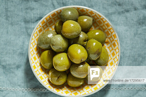 Draufsicht auf grüne Oliven in einer Schale