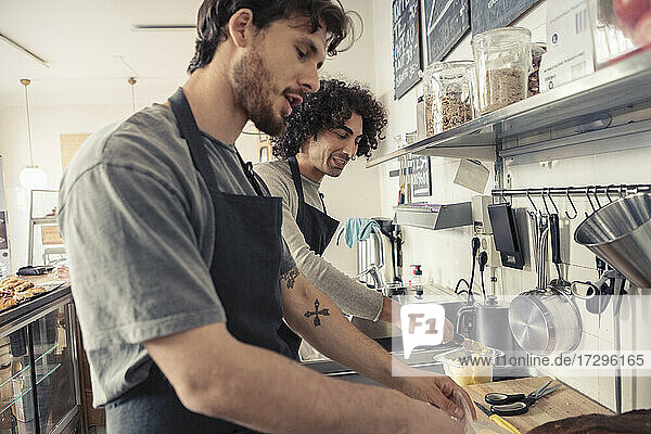Männliche Unternehmer diskutieren bei der gemeinsamen Arbeit im Cafe