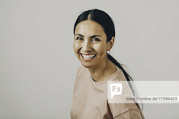 Porträt der fröhlichen Mitte erwachsene Frau gegen weißen Hintergrund