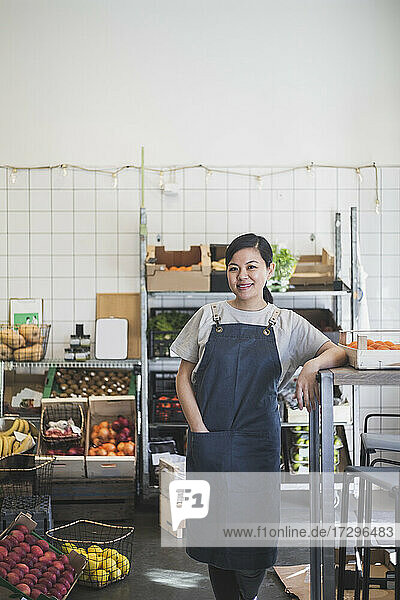 Porträt einer lächelnden Unternehmerin mit Hand in der Tasche im Geschäft