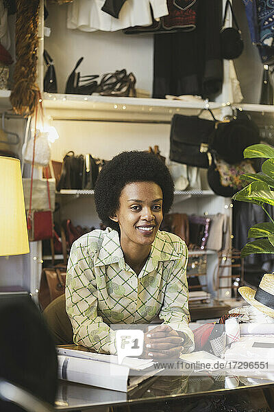 Afrikanische Mitarbeiterin lehnt sich im Laden an einen Tisch