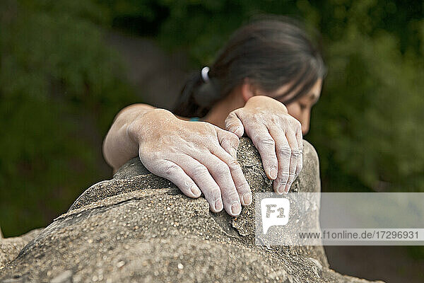 Frau klettert auf den Sandsteinfelsen am Harrison's Rock in England