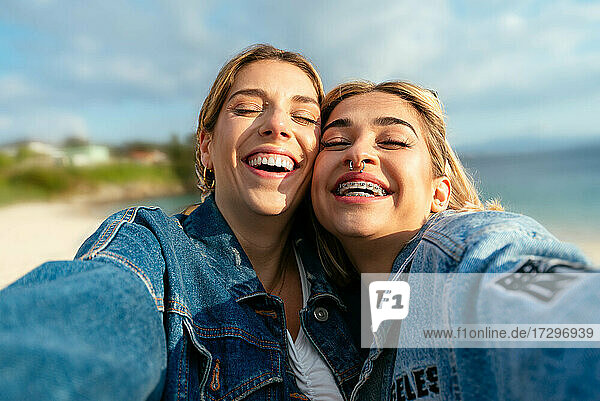 Zwei schöne lächelnde Freundinnen machen ein Selfie