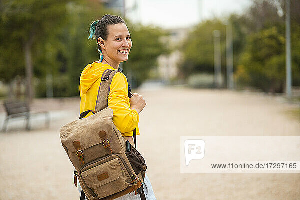 Spanish student with backpack and smile looking back