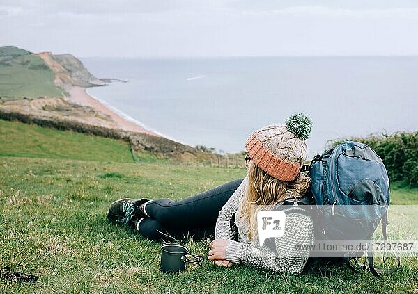 woman sat with a cup of tea having a break hiking the Jurassic coast