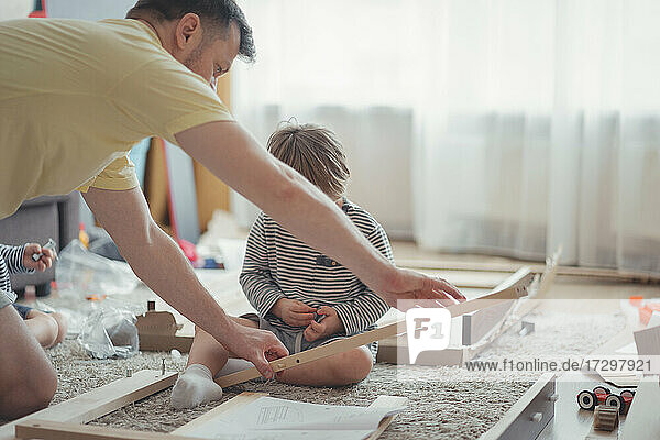 House furniture assembly process  Father and children assembling table