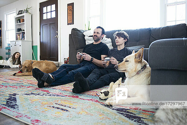 Vater und kleiner Sohn spielen zusammen Videospiele.
