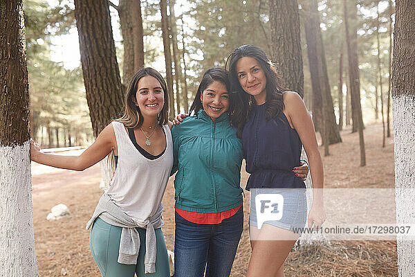 group of friends looking at the camera in the middle of the forest
