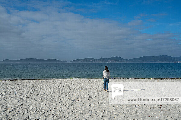 Frau beim Spaziergang auf dem weißen Sand des Strandes von Oia in Galicien  Spanien