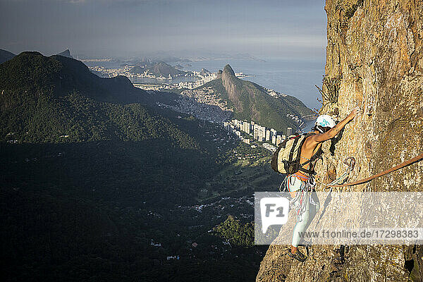 Beautiful view to female climber on steep rocky rainforest mountain
