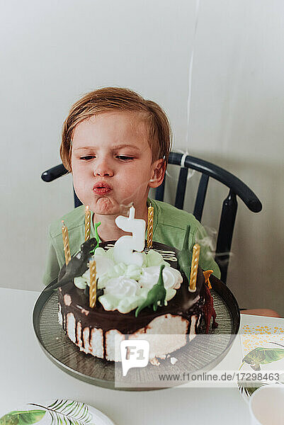 Junge 5 Jahre alt Junge bläst seine Geburtstagskerze aus