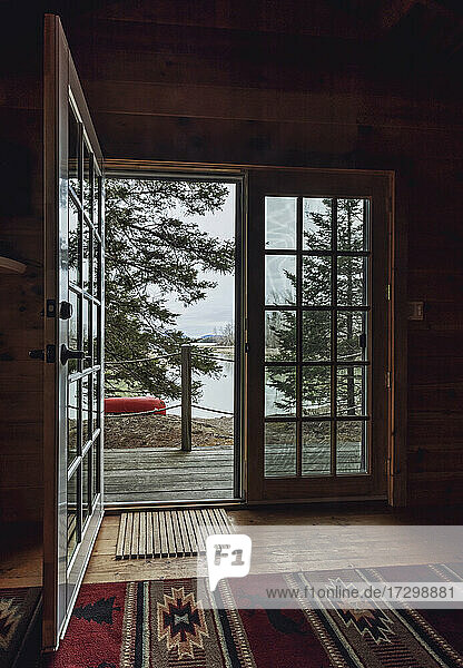 Innenansicht durch eine offene Tür mit Blick auf Wald und Wasser  Küste von Maine
