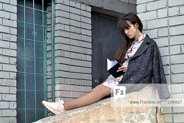 Porträt eines Mädchens  das im Freien seine Notizen liest
