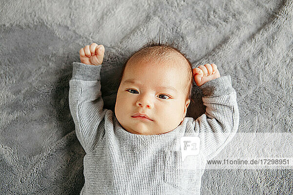 Cute zwei Monate neugeborenen asiatischen chinesischen Baby Junge auf dem Bett liegend suchen.