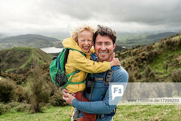 Glücklicher Vater und lächelnder Sohn bei einer Wanderung in Neuseeland