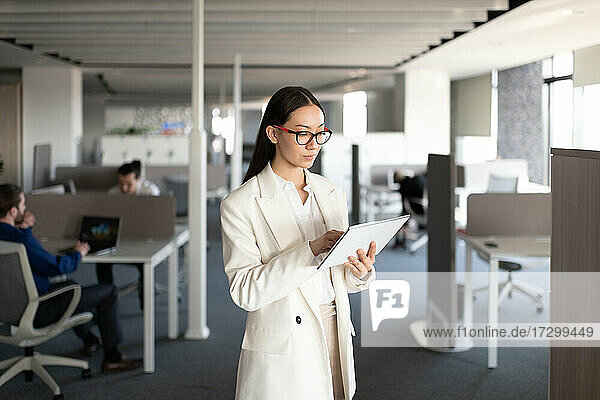 Asiatische Geschäftsfrau mit Tablet am Arbeitsplatz