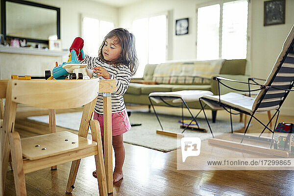 Nettes Mädchen spielt mit Spielzeug auf dem Tisch im Wohnzimmer zu Hause