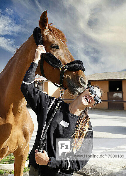 Pferderennjockey mit ihrem Pferd  das sie küsst  streichelt und umsorgt