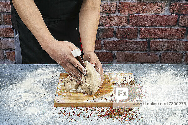 Bäcker gibt Samen in den Brotteig