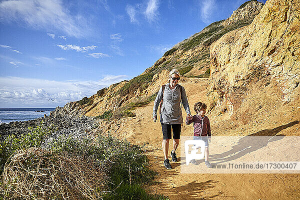 Senior woman hiking with grandson during sunny day