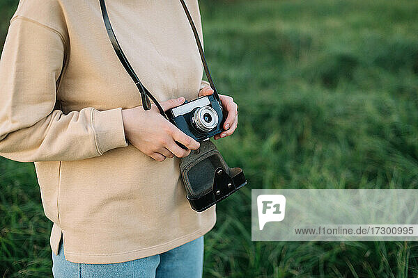 Pretty woman holding film camera in a field