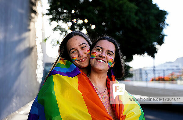 schönes lesbisches Paar  das sich auf der Straße mit einer lgtb-Fahne amüsiert