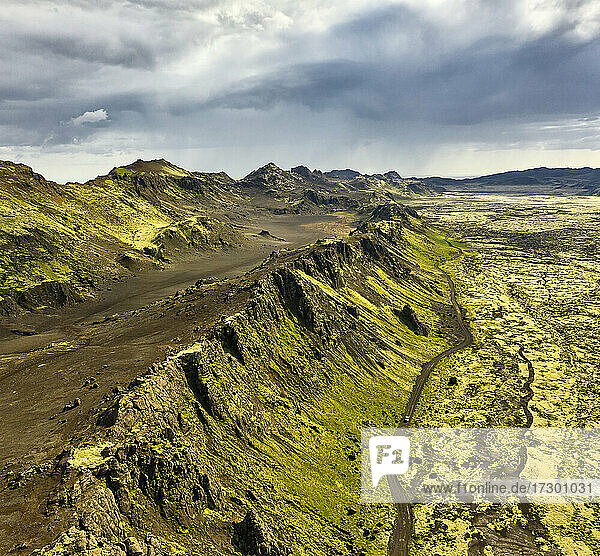 Luftaufnahme der Berge in der Nähe der Straße und des trockenen Geländes an einem bewölkten Tag in Island
