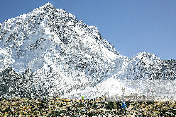 Bergsteiger auf dem Weg zum Everest Basecamp  im Hintergrund der Nuptse