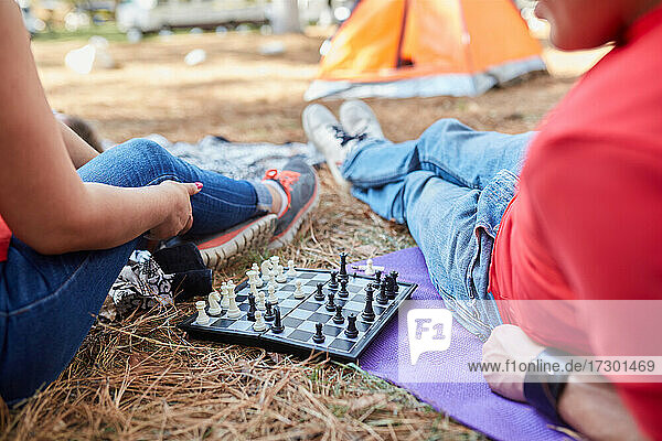 Ein paar Freunde spielen Schach vor ihrem Zelt