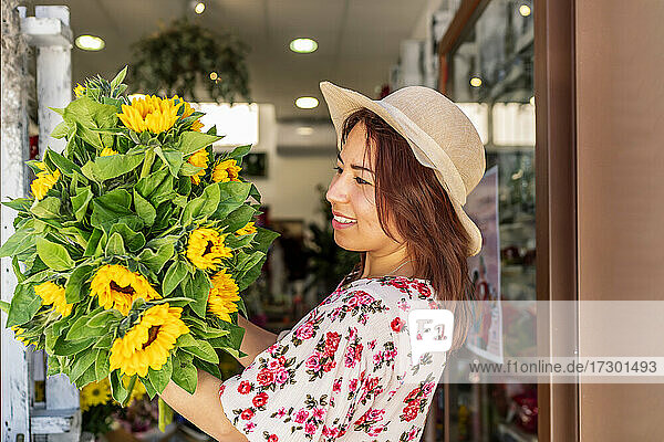 schöne Frau mit einem Strauß Sonnenblumen in den Händen