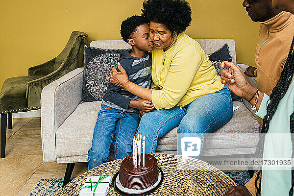 Großmutter umarmt Enkel bei Geburtstagsfeier zu Hause