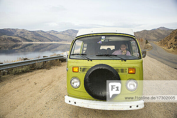 Eine Frau und ihr Hund sind durch die Windschutzscheibe eines VW-Wohnmobils zu sehen