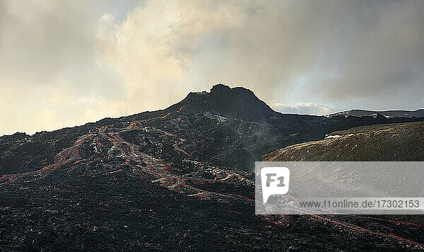Dramatischer aktiver Vulkan mit fließender heißer Lava