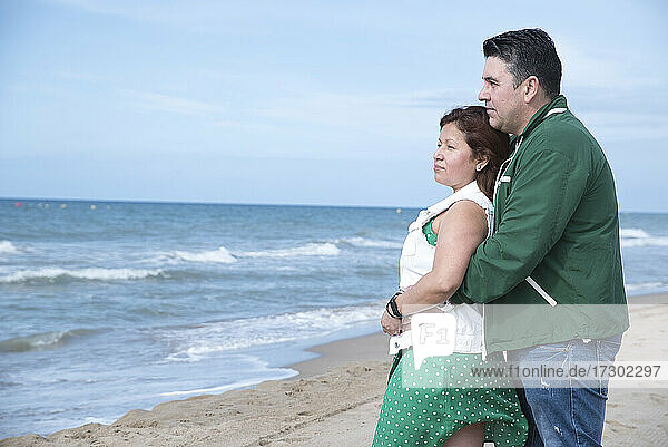 Verliebtes Paar  hispanischer Mann mit lateinamerikanischer Frau  die am Strand spazieren gehen.