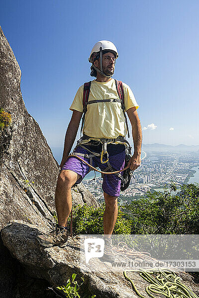 Beautiful view to male rock climber on rocky rainforest mountain