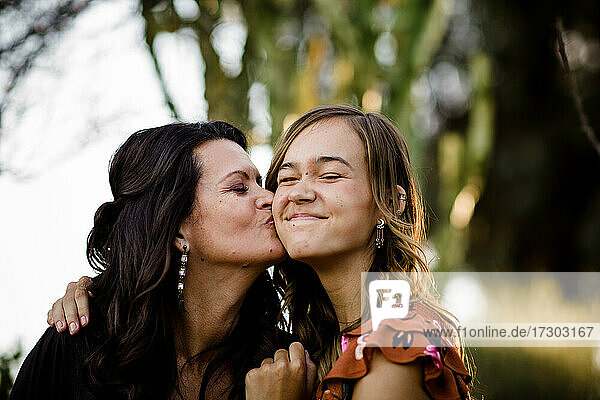 Mother Kissing Teenage Daughter in Desert Garden in San Diego
