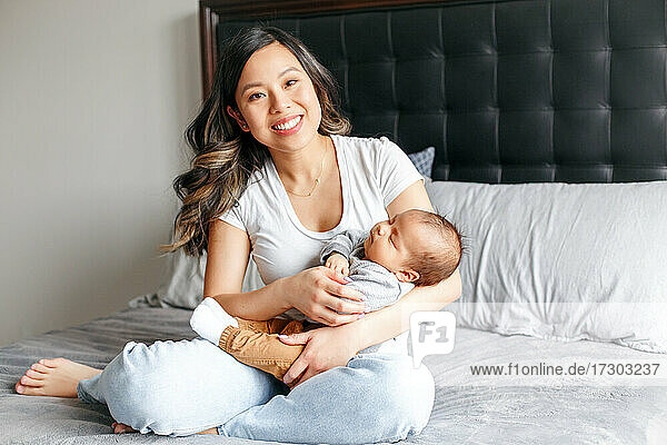 Muttertag Urlaub. Lächelnde chinesische asiatische Mutter mit neugeborenem Baby.