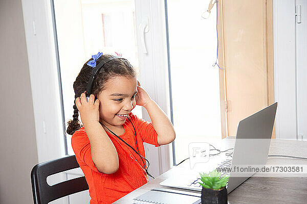 baby studying at home with his laptop and headphones . distance learning concept