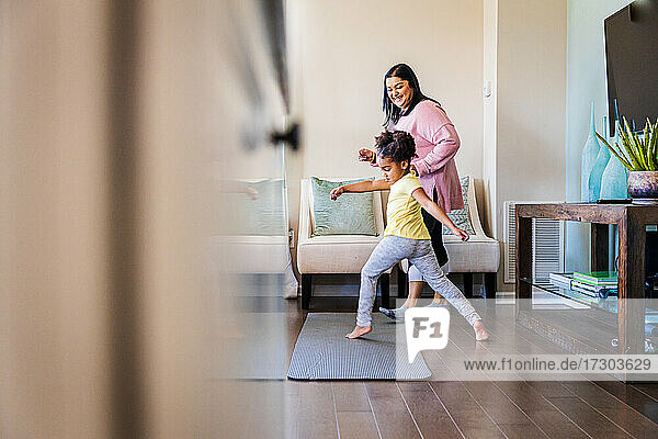 Mädchen übt Tanz mit lächelnder Großmutter zu Hause