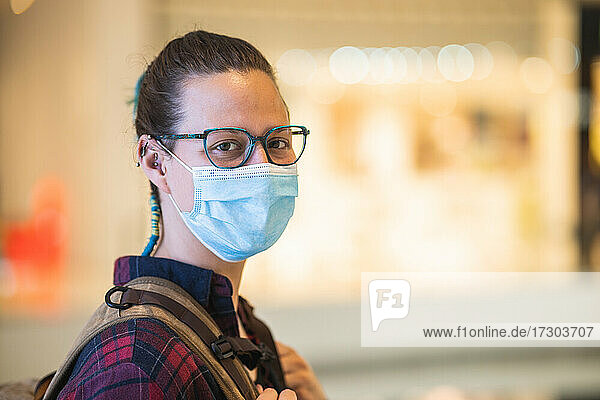 Spanish woman with mask and glasses shopping in mall with copy space