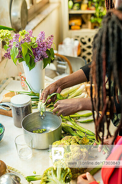 Schwarze Frau bei der Arbeit mit Gemüse in der Küche