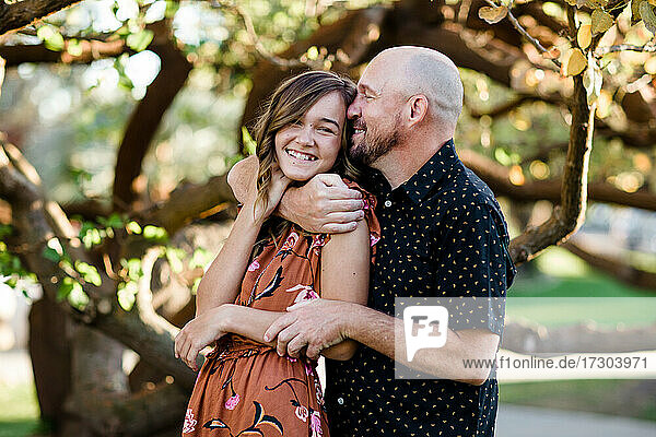 Father Hugging Teenage Daughter in Garden in San Diego