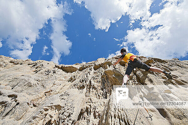 Frau beim Klettern an den Kalksteinfelsen von Swanage / Großbritannien