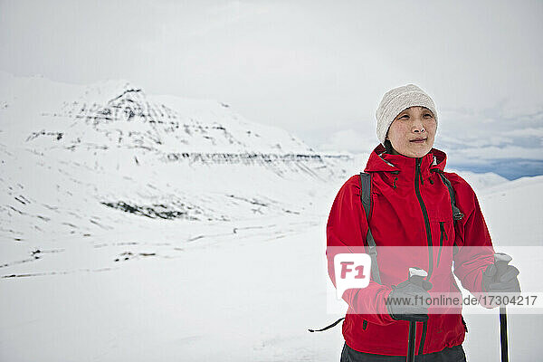 Frau beim Wandern in den Bergen von Nordisland im Winter
