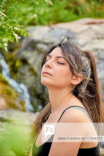 Weiße kaukasische Frau mit braunem Haar in einem Pferdeschwanz  Augen geschlossen. Konzept  Gefühl  Meditation  Yoga