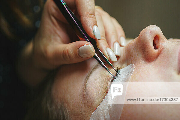 Aesthetic medicine: beauty eyelash extension procedure for a girl
