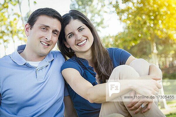 Young attractive couple intimate portrait outdoors in the park